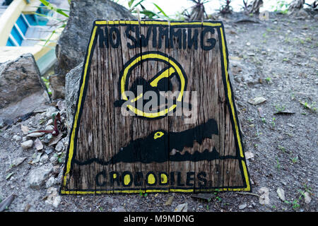 Humorous sign banning swimming due to the danger of crocodiles in northern Guatemala Stock Photo