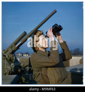 1940’s WW2 December 1942 A British Auxiliary Territorial Service (ATS) ‘spotter’ at a 3.7-inch anti-aircraft ‘ack ack’ gun site searching for visual signs of Nazi Germany Luftwaffe enemy aircraft or unmanned flying V1/V2 bombs. Stock Photo