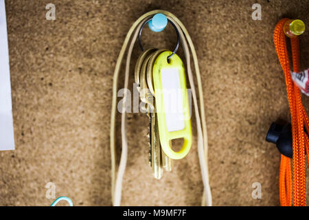 Door keys isolated on cork background, close up. Stock Photo