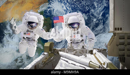 Astronauts floats in space holding USA flag. Artist expression of orbital ISS activity. Altered composite from elements image furnished by NASA. Stock Photo