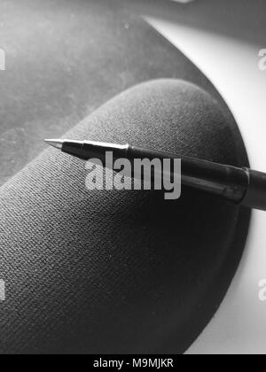 used ballpoint pen lying on a mouse pad, Close up black and white image, Macro photo, Stock Photo