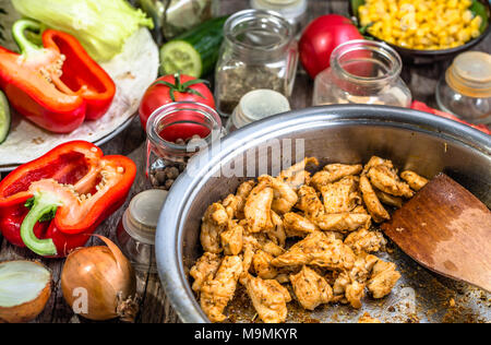 Preparing tortilla with gyros meat, chicken stripes fried on pan and vegetables, homemade cooking recipe Stock Photo
