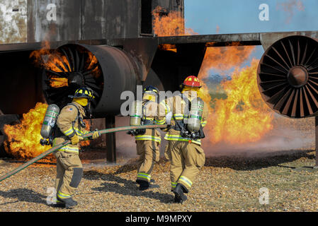 Firefighters from the 100th Civil Engineer Squadron, extinguish an aircraft fire as part of annual proficiency skill training for firefighters at their training burn pit on RAF Mildenhall, England, March 21, 2018. The fire department holds this training to keep fire team members proficient in aircraft incidents. (U.S. Air Force photo by Tech. Sgt. Emerson Nuñez) Stock Photo