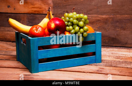 Farmer with wooden crate full of different vegetables in field ...