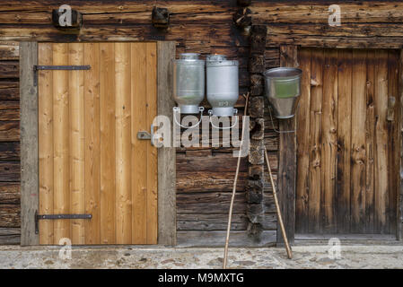 Milk pots hanging on stable wall, mountain village Oberstalleralm, Innervillgraten, Tyrol, Austria Stock Photo