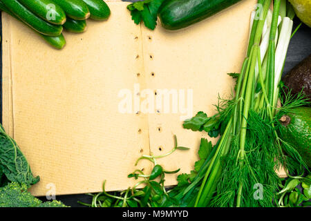 fresh green vegetables frame with notebook on a table close up Stock Photo