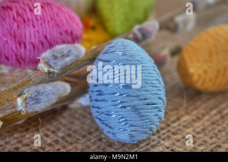 Colorful easter eggs and willow branch on natural jute fabric background. The concept of a happy Easter Stock Photo