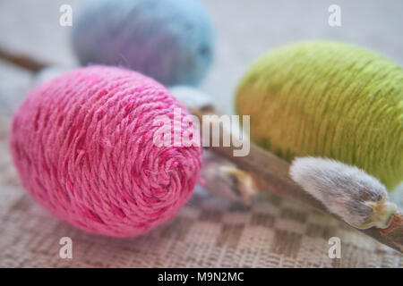 Colorful easter eggs and willow branch on a natural patterned linen tablecloth background. The concept of a happy Easter Stock Photo