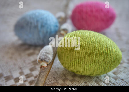 Colorful easter eggs and willow branch on a natural patterned linen tablecloth background. The concept of a happy Easter Stock Photo