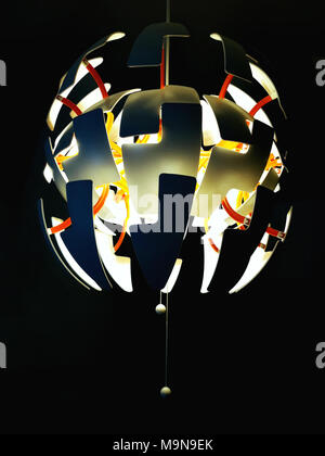 Ceiling chandelier with luminous light bulbs on black background. Stock Photo