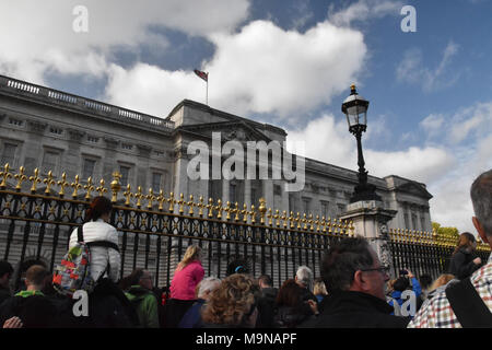 Crowds gather outside the gates at Buckingham Palace to watch the Changing of the Guard.