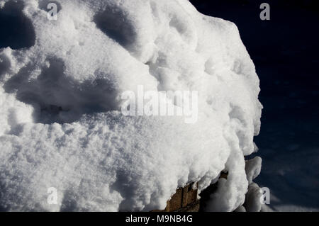Snow pile covering bricks Stock Photo