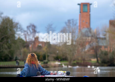 girl with red curly hair stood on front of canal boat with typical english buildings in background and fantastic light Stock Photo