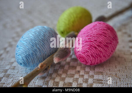 Colorful easter eggs and willow branch on a natural patterned linen tablecloth background. The concept of a happy Easter Stock Photo