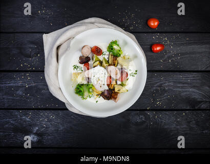 Salad of grilled vegetables with sausages and poached egg. Stock Photo