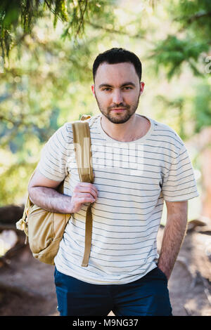 Smiling happy handsome man with beard in forest, mountains, park. Traveler Man relaxing . Travel Lifestyle hiking concept summer vacations outdoor. Be Stock Photo