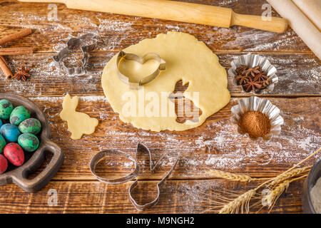 Still life on a wooden background. Preparation for Easter baking. Figured forms for cookies. Stock Photo