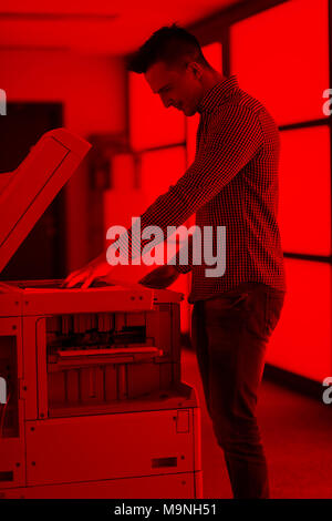 young business man copy documents on copy machine at modern startup office interior, casual clothes Stock Photo