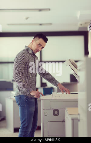 young business man copy documents on copy machine at modern startup office interior, casual clothes Stock Photo
