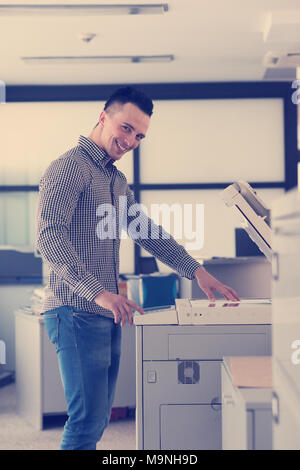 young business man copy documents on copy machine at modern startup office interior, casual clothes Stock Photo