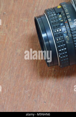 manual camera lens on wooden board Stock Photo
