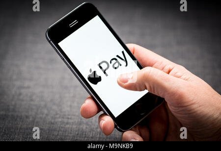A man using Apple Pay on an iPhone Stock Photo