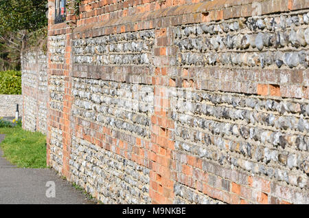 Old flint stone wall with bricks in the UK. Stock Photo