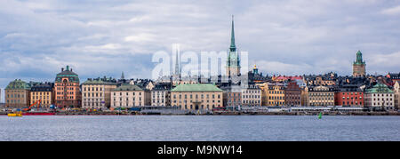 Gamla Stan in Stockholm, the medieval houses on Skeppsbron viewed from the sea Saltsjon, a cloudy day in march. There are still icefloes in the sea. T Stock Photo
