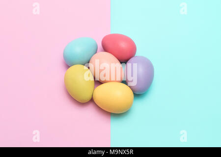 Six colourful easter eggs placed in a flower shape on the punchy pastel background. Stock Photo