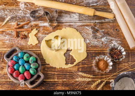 Still life on a wooden background. Pastry for cookies with figured forms for Easter baking. Stock Photo