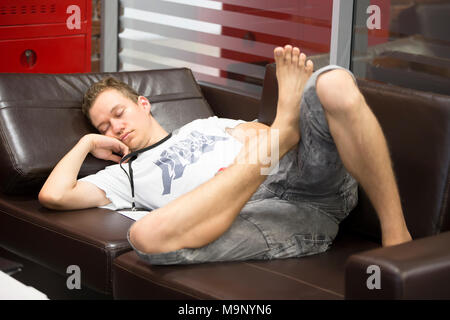 Belarus Minsk 06 August 2016 The Park of High Technologies. Competitions programmers.The man fell asleep on the leather couch.The young guy was tired  Stock Photo