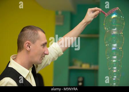 Belarus, Gomel, November 9, 2017. Gomel Children's Center. Children's holiday. A man blows bubbles. Inflate the soap bubble Stock Photo