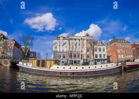 Outdoor view of houseboats and apartment buildings on a canal in the city of Amsterdam Stock Photo