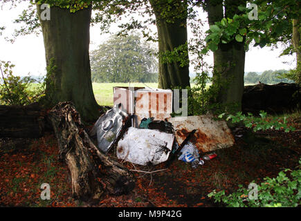 Rubbish dumped in woods. Illegal countryside fly-tipping and rural vandalism spoiling the rural environment in Kent, UK. Stock Photo