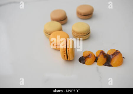 chocolate and orange flavor macaroon biscuits on white marble Stock Photo