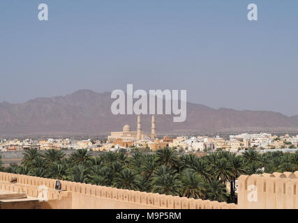 Mosque with minaret, palm oasis, in the back Al Hajar Mountains, Nakhl, Oman Stock Photo