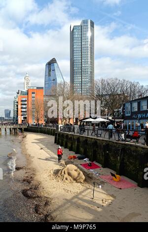 The south bank of the Thames with a sand sculpture on the foreshore and new high rise buildings next to the Oxo Tower Central London England UK Stock Photo