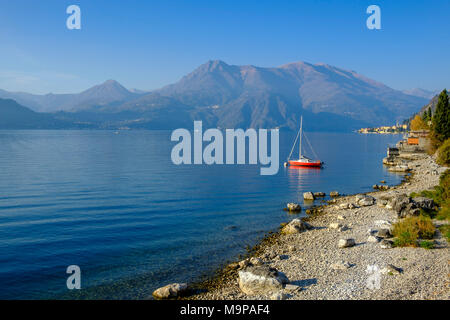 Red sailing boat on the shore, Lake Como, Varenna, Lago di Como, Lombardy, Italy Stock Photo