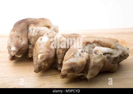 Pigs trotters that have been boiled until tender and left to cool before being eaten with a splash of vinegar UK. Pigs trotters are rich in collagen. Stock Photo