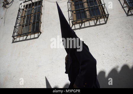 Granada, Granada, Spain. 27th Mar, 2018. A penitent from the ''Via Crucis'' brotherhood on his way to the church, situated on Albaicin neighbourhood.Every year thousands of christians believers celebrates the Holy Week of Easter with the crucifixion and resurrection of Jesus Christ. Credit: Carlos Gil/SOPA Images/ZUMA Wire/Alamy Live News Stock Photo