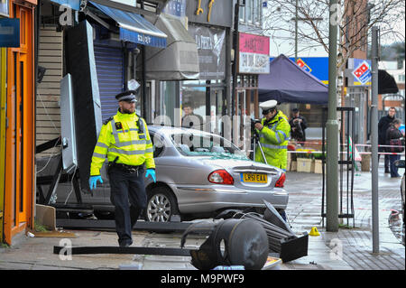 London, UK.  28 March 2018.  A silver Jaguar car has crashed into a pharmacy in Golders Green, north London following a road traffic accident.  It is reported that two people were taken to hospital with injuries.  Golders Green Road is currently cordoned off while police attend the scene.  Credit: Stephen Chung / Alamy Live News Stock Photo