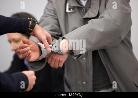 Defendant in trial for assault on a postal agency in Koblenz enters the courtroom in handcuffs, Koblenz Regional Court Stock Photo