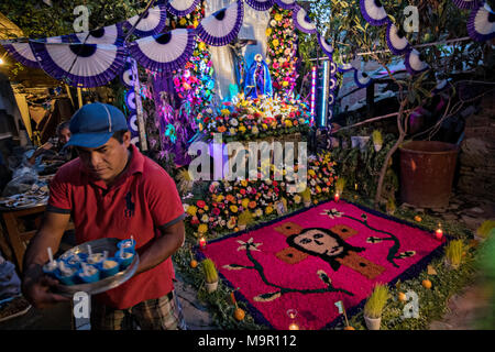 A Mexican man arranges ice cream cups to be given to visitors stopping to see the family altar celebrating El Viernes de Dolores during Holy Week March 23, 2018 in San Miguel de Allende, Mexico. The event honors the sorrow of the Virgin Mary for the death of her son and is an annual tradition in central Mexico. Stock Photo