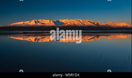 Khoton Lake, snow-covered mountains with dawn in the back, Mongolia Stock Photo