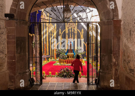 A Mexican woman prepares an altar celebrating El Viernes de Dolores during Holy Week March 23, 2018 in San Miguel de Allende, Mexico. The event honors the sorrow of the Virgin Mary for the death of her son and is an annual tradition in central Mexico. Stock Photo