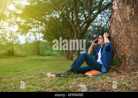 young man in stress situation when talking on mobile phone in the park Stock Photo