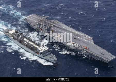 180326-N-AD724-0055 ATLANTIC OCEAN (March 26, 2018) The Nimitz-class aircraft carrier USS Abraham Lincoln (CVN 72) performs an ammunition onload with the fast combat support ship USNS Supply (T-AOE 6). (U.S. Navy photo by Mass Communication Specialist Seaman Shane Bryan/Released) Stock Photo