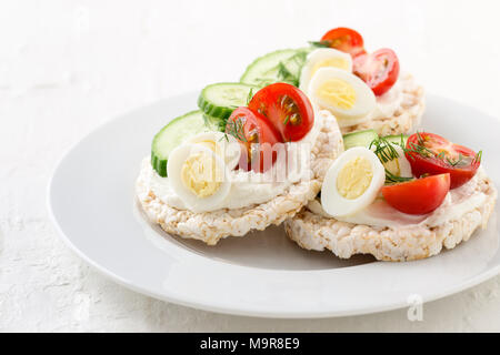 Open sandwiches of rice cakes with cream cheese , vegetables and quail egg, healthy snack Stock Photo