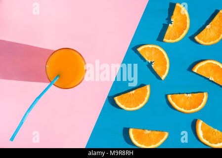 Summer image from a high angle view with a glass of healthy orange juice and a multitude of orange slices Stock Photo