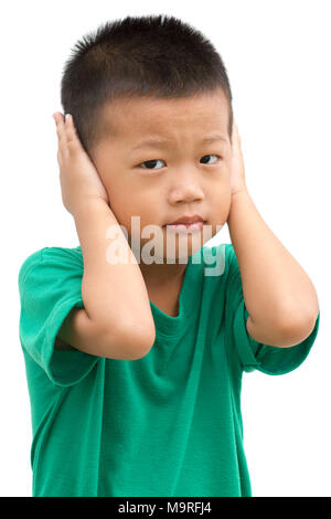 Asian child covering his ears with hands. Portrait of young boy isolated on white background. Stock Photo